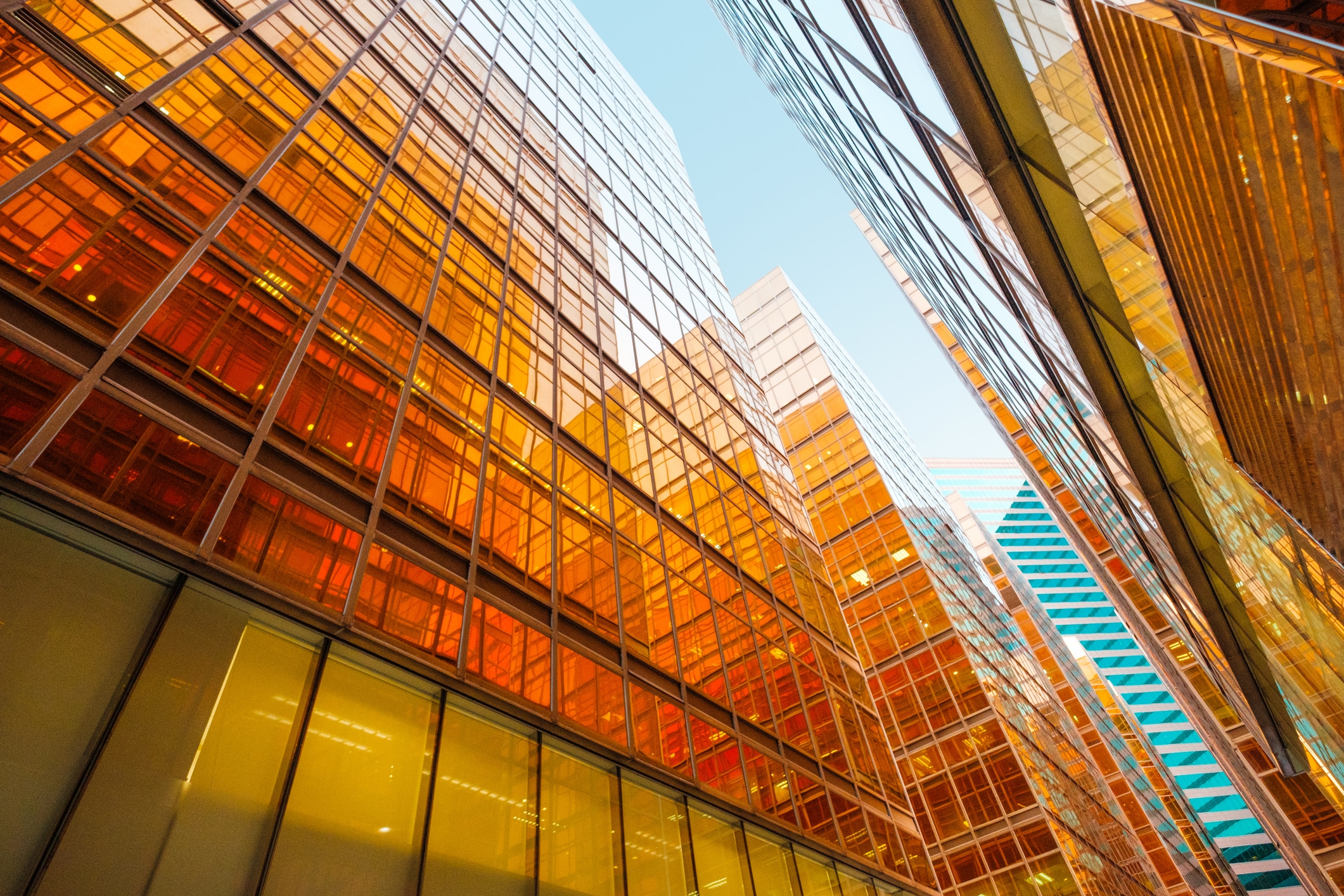 golden glass facade of modern office building and blue sky